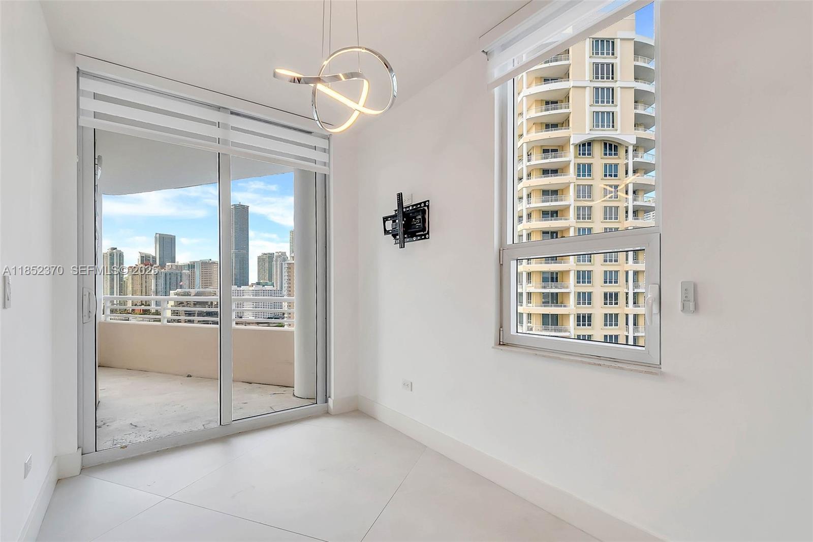 848 Brickell Key Drive, Unit 1906 Miami, FL 33131 - Photo 9 of 18 a view of a big room with windows and chandelier