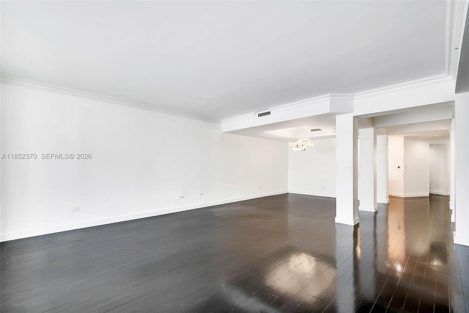 848 Brickell Key Drive, Unit 1906 Miami, FL 33131 - Photo 9 of 24 an empty room with wooden floor and windows