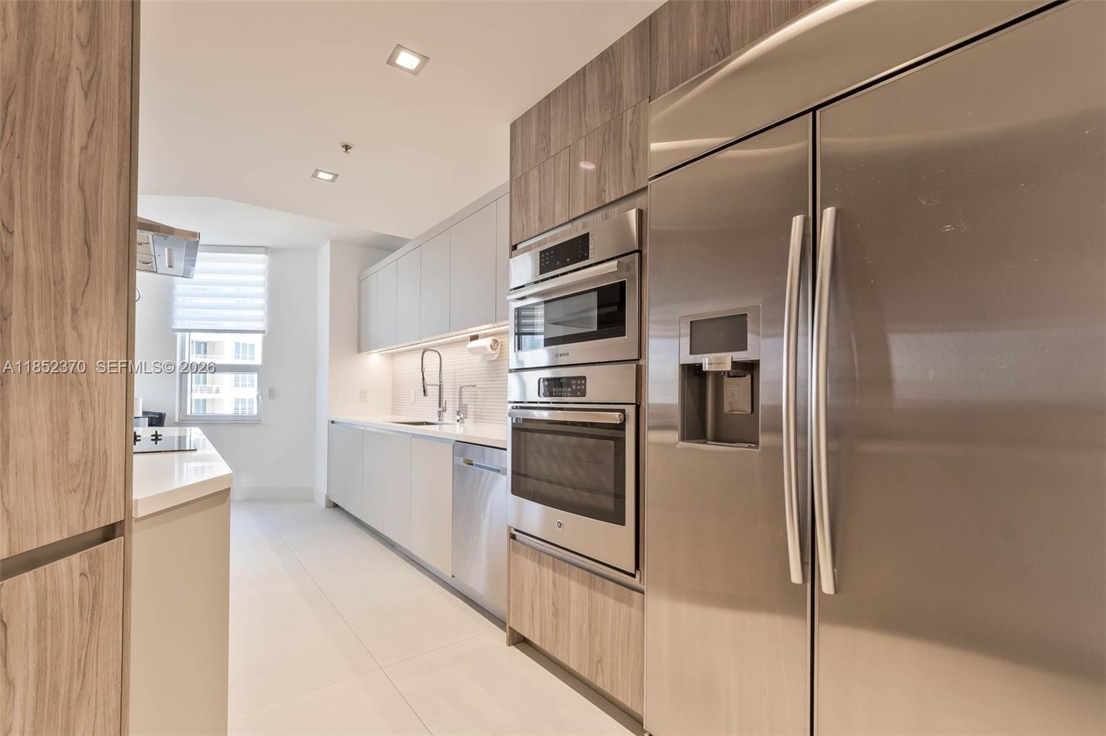 848 Brickell Key Drive, Unit 1906 Miami, FL 33131 - Photo 10 of 24 a kitchen with stainless steel appliances a refrigerator and a stove top oven