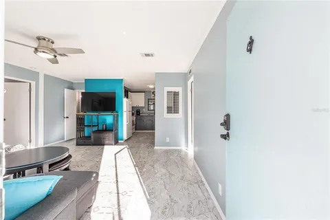 a living room with a fireplace furniture a ceiling fan and a window