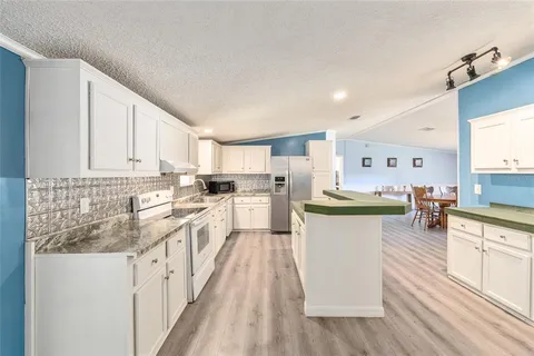 a bedroom with a bed dresser and a wooden floor