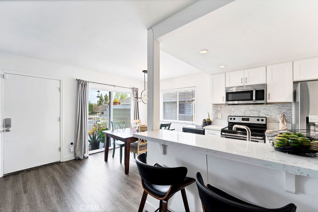 4267 Arcata Bay Way Oceanside, CA 92058 - Photo 20 of 34 a kitchen with granite countertop a stove a sink a dining table and chairs