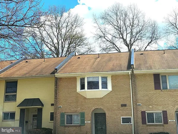 a view of a white house with large windows and a large tree