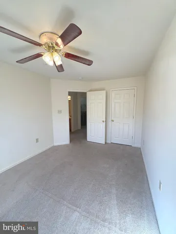 a view of an empty room and chandelier fan