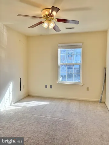 an empty room with a window and a ceiling fan