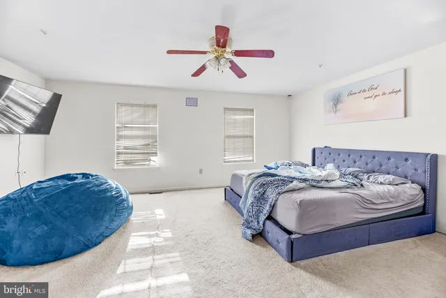 a spacious bedroom with a bed and a chandelier