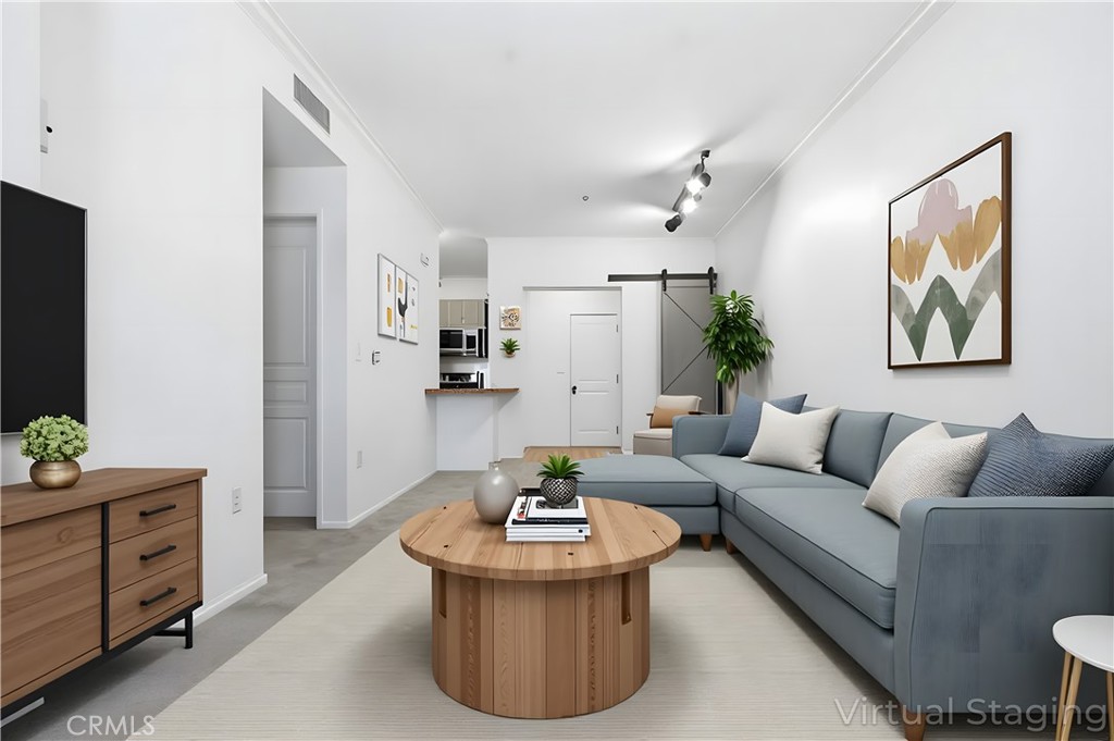 a living room with furniture and view of kitchen