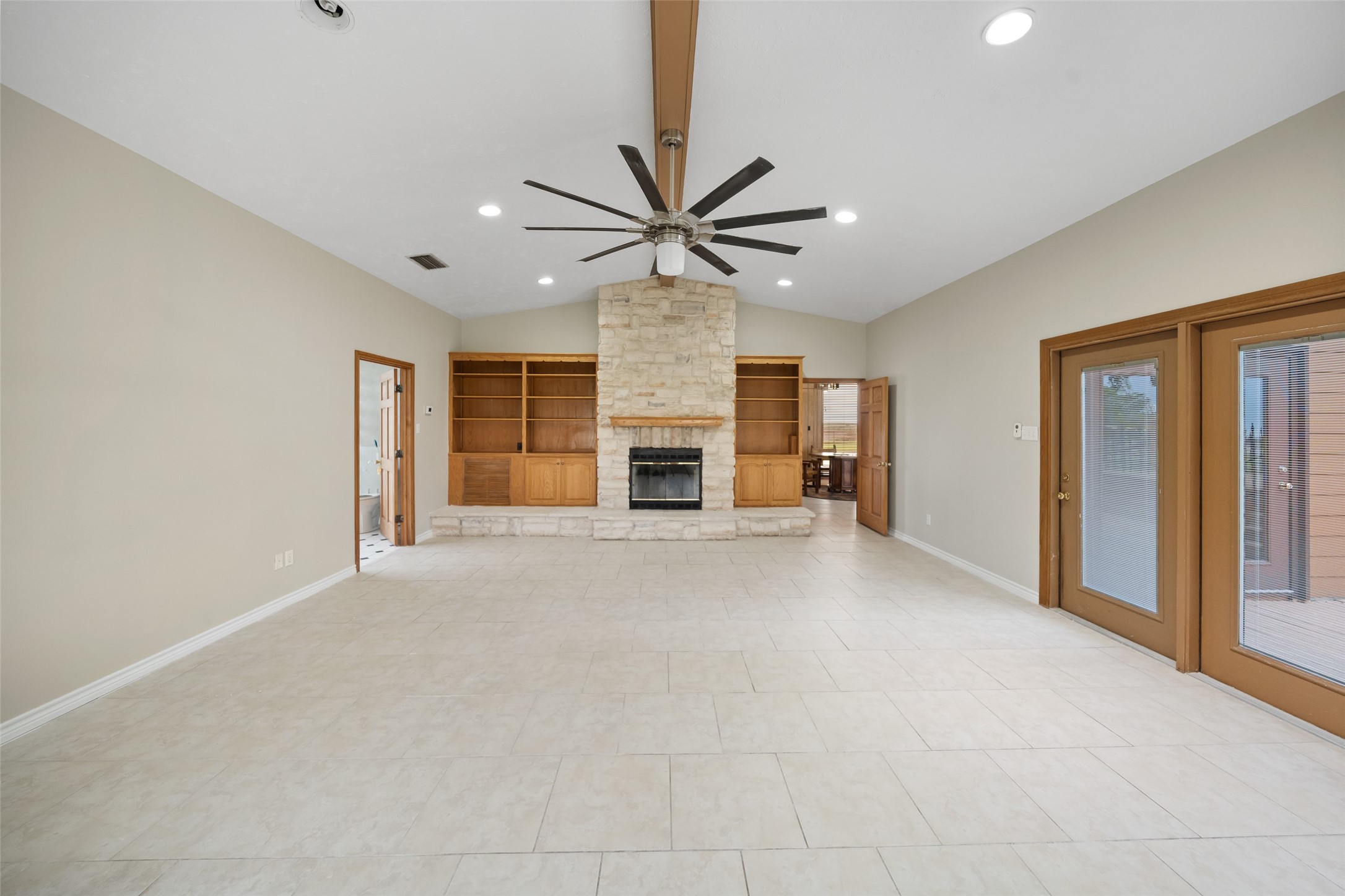 119 Fm 1891 Shiner, TX 77984 - Photo 6 of 40 a view of a livingroom with a fireplace a chandelier fan and windows