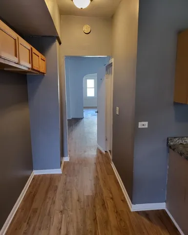 a view of a hallway with wooden floor and a cabinet