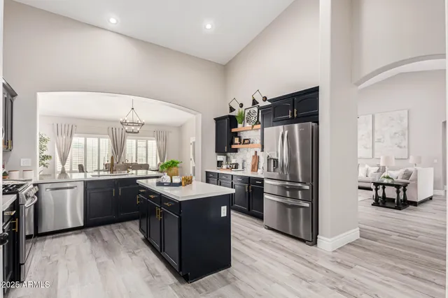 a kitchen with stainless steel appliances kitchen island granite countertop a refrigerator and a stove top oven