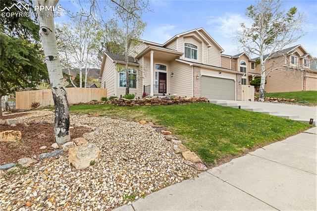 7510 Julynn Road Colorado Springs, CO 80919 - Photo 2 of 36 View of front facade featuring a garage and landscaping