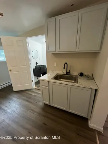 a kitchen with a sink a microwave a refrigerator and cabinets