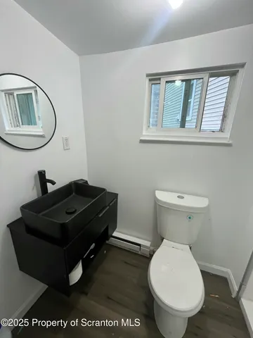 a bathroom with a toilet a sink and mirror