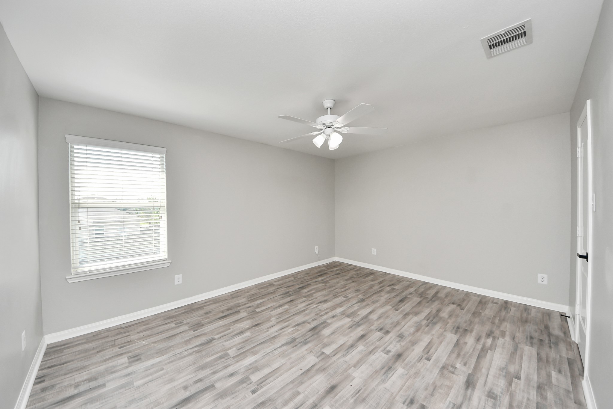 6931 Primrose Road Baytown, TX 77521 - Photo 35 of 50 Spacious 2nd bedroom with large window for natural light, neutral paint tones, and wood-look flooring.