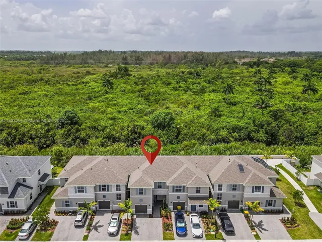 an aerial view of a city with lots of residential buildings ocean and mountain view in back