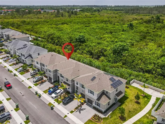an aerial view of residential houses with outdoor space and swimming pool