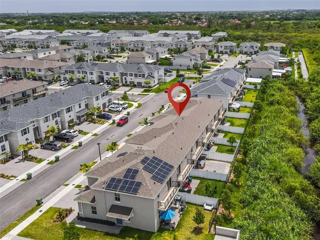 an aerial view of multiple houses with a yard