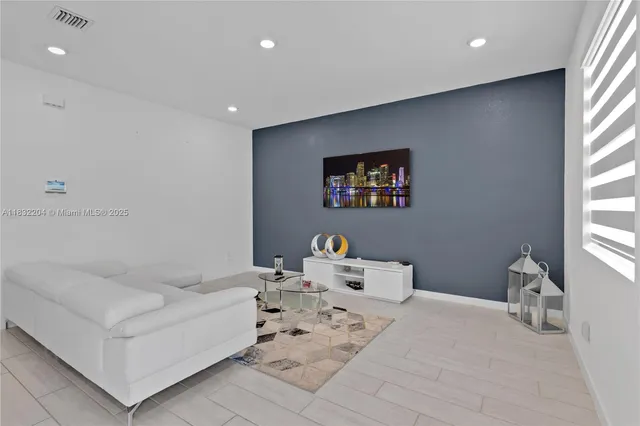 a living room with furniture and kitchen view