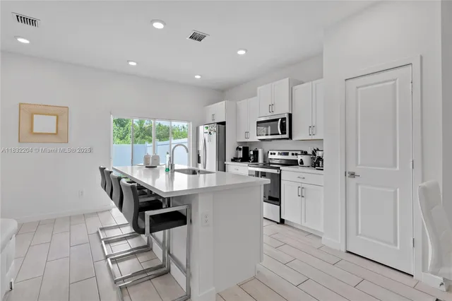a kitchen with stainless steel appliances granite countertop a sink and stove top oven