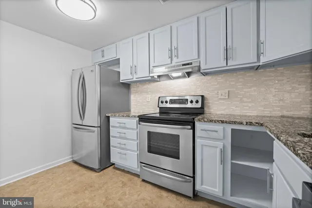 a kitchen with stainless steel appliances granite countertop a stove a refrigerator and a sink