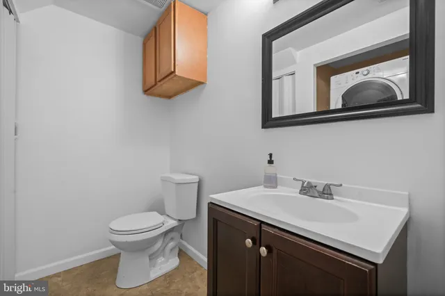 a bathroom with a toilet a sink and mirror