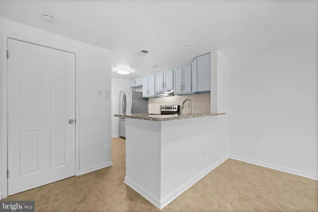 a kitchen with stainless steel appliances granite countertop a refrigerator sink and cabinets