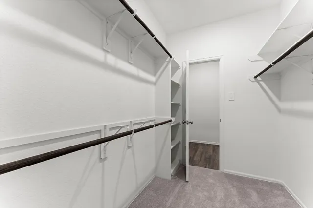 an empty room with an entryway and wooden floor