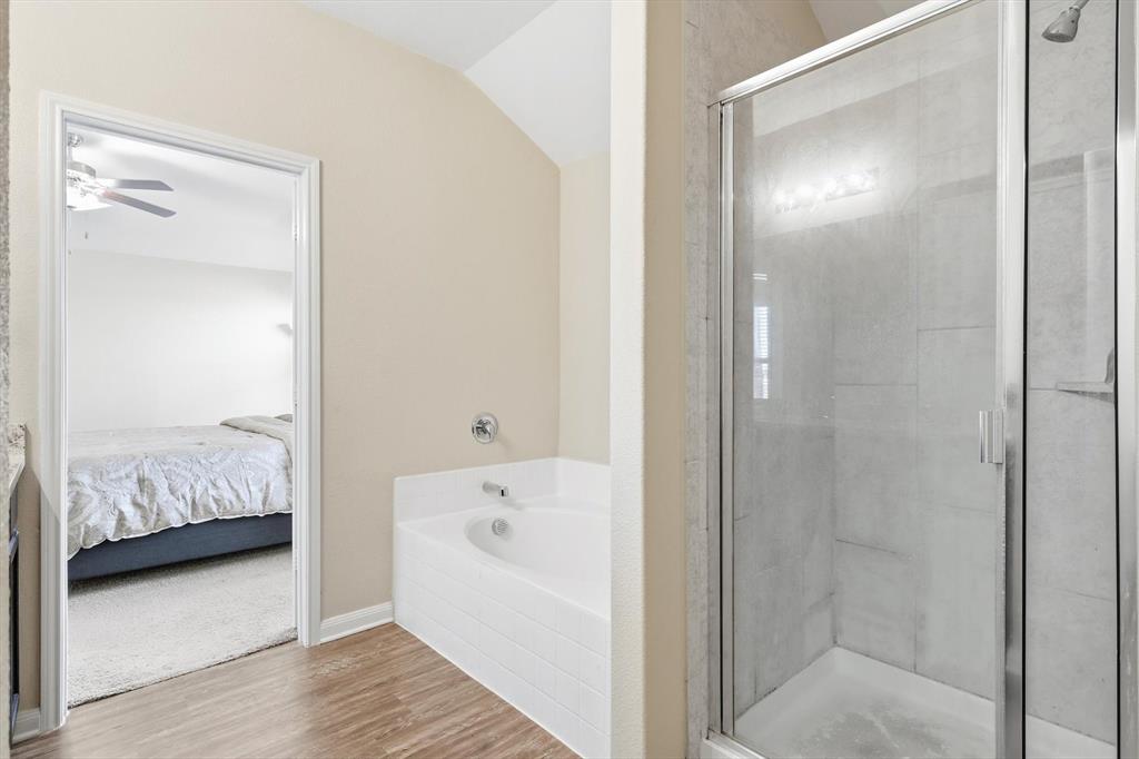 227 Curt Street Anna, TX 75409 - Photo 22 of 40 Ensuite bathroom featuring a stall shower, a garden tub, wood finished floors, and lofted ceiling