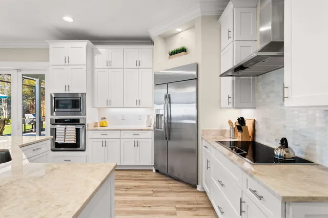 a kitchen with a sink dishwasher and white cabinets with wooden floor