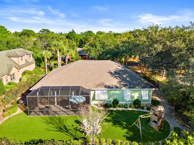a view of a brick house with large trees