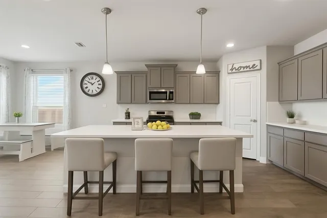 a kitchen with a dining table chairs and white cabinets