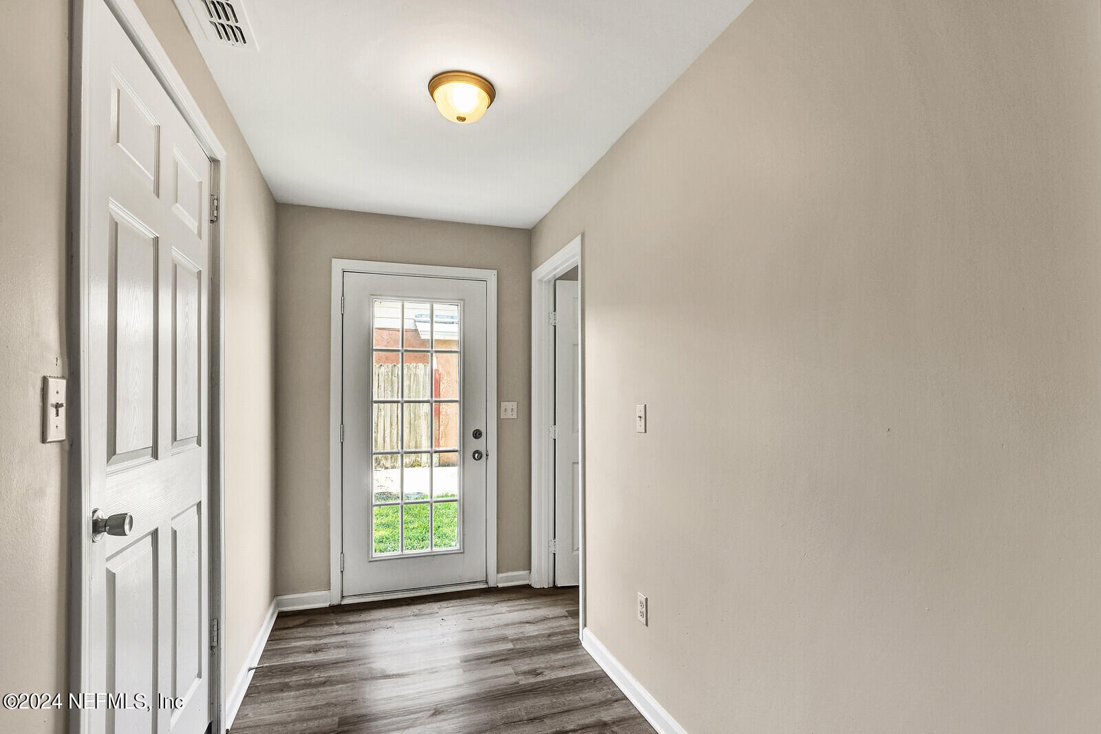4503 Barnes Road South Jacksonville, FL 32207 - Photo 22 of 24 a view of an empty room with wooden floor and a window