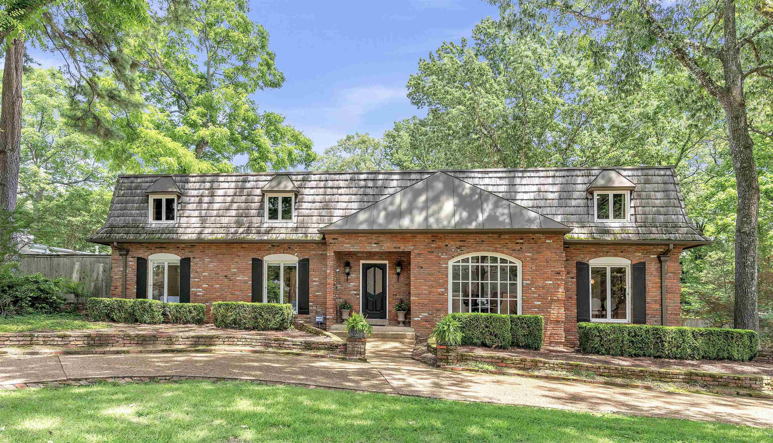 Front of property with brick siding and a front yard