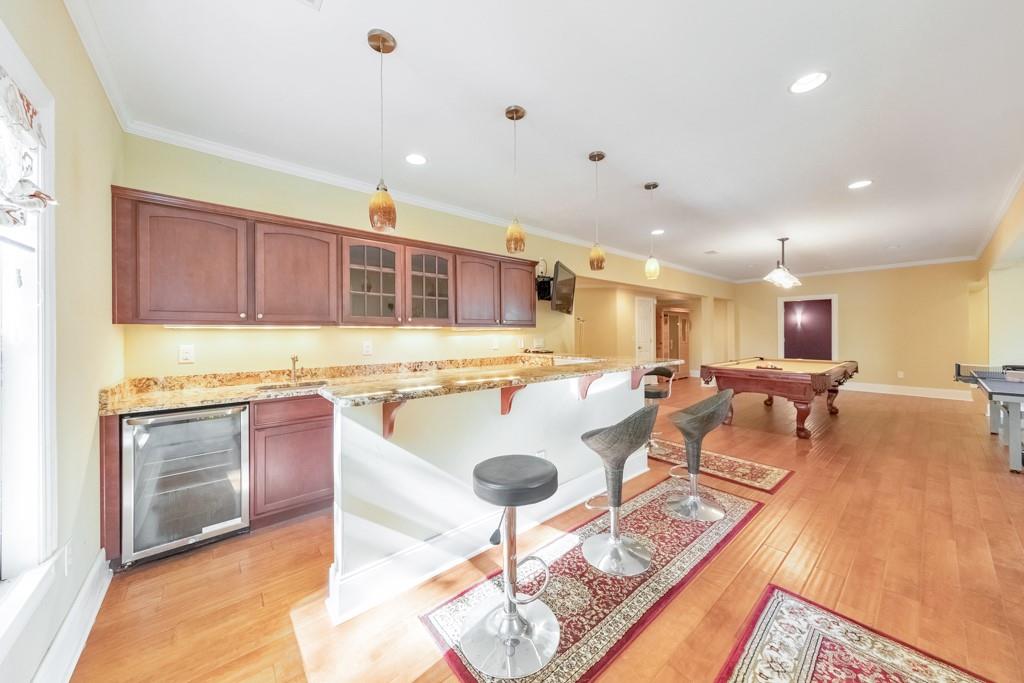 3161 Willowstone Drive Duluth, GA 30096 - Photo 49 of 72 a kitchen with stainless steel appliances granite countertop a sink a stove a dining table and chairs with wooden floor