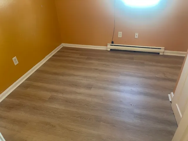 a view of a room with wooden floor