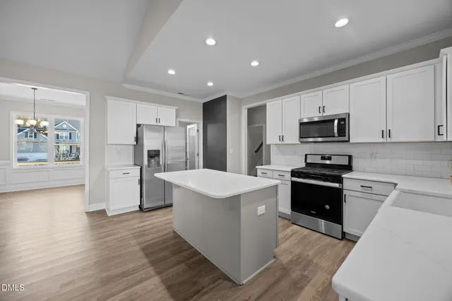 a kitchen with stainless steel appliances kitchen island granite countertop a refrigerator stove microwave and sink