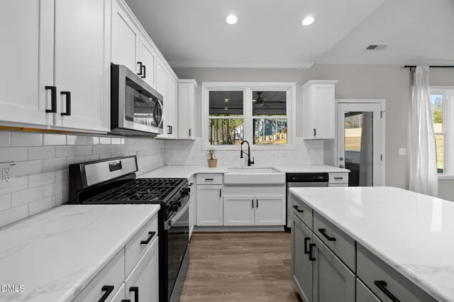 a kitchen with stainless steel appliances a sink stove and cabinets
