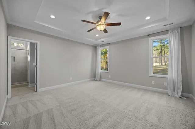 an empty room with window and ceiling fan