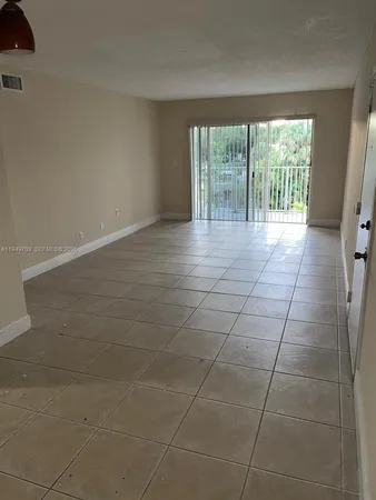 a view of a livingroom with a floor to ceiling window and an empty room