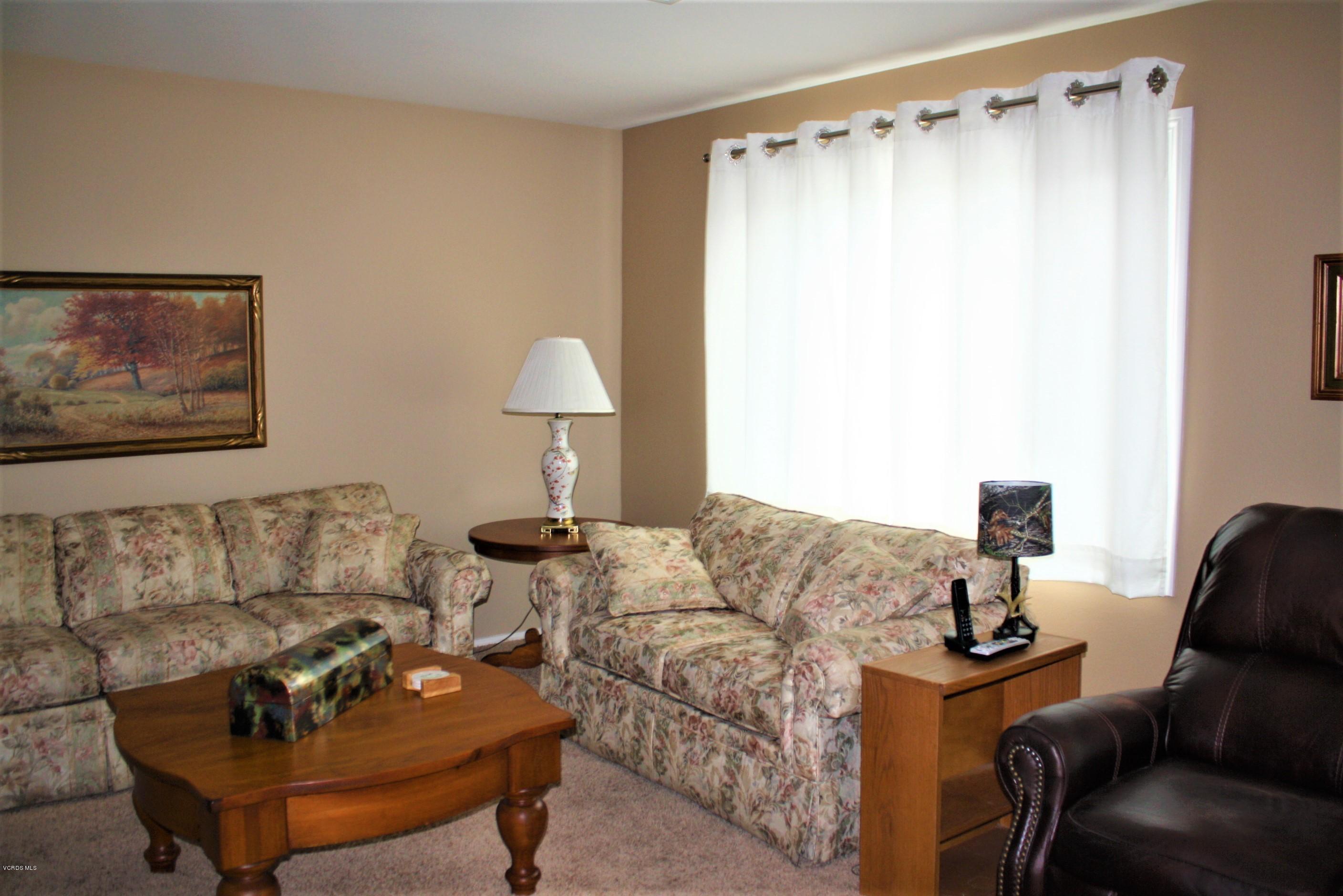 6480 Katherine Road, Unit 107 Simi Valley, CA 93063 - Photo 9 of 22 a living room with furniture and a lamp