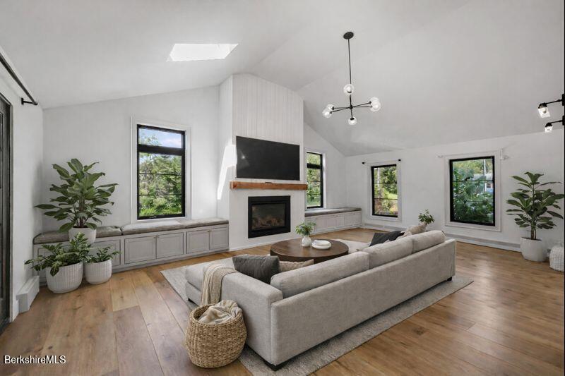 65 Johnson Road Dalton, MA 01226 - Photo 19 of 76 a living room with furniture a fireplace and a chandelier