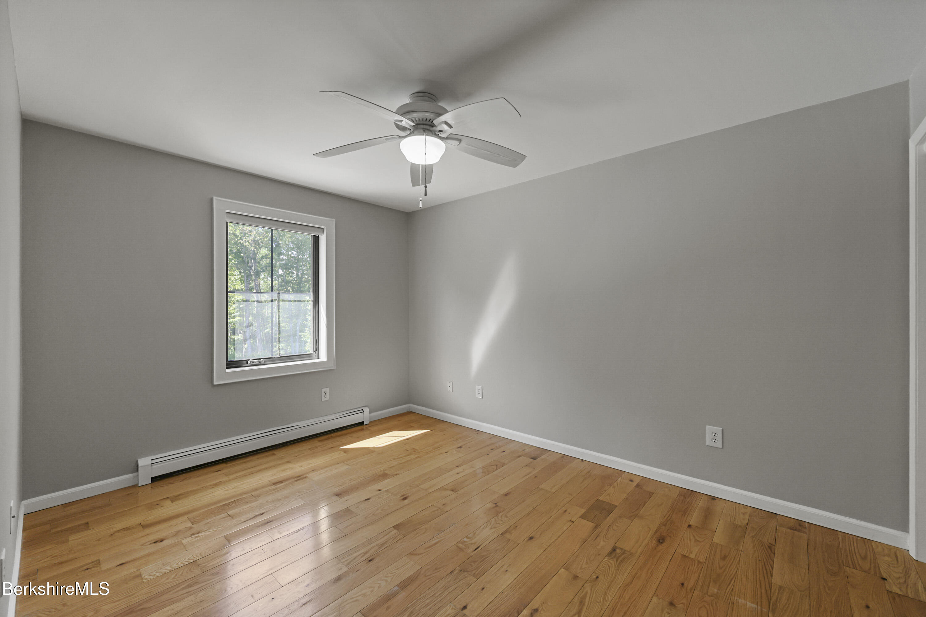 65 Johnson Road Dalton, MA 01226 - Photo 45 of 76 an empty room with wooden floor fan and windows