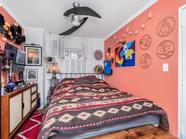 a bedroom with a bed and painting on the wall