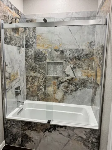 a bathroom with a bathtub and shower