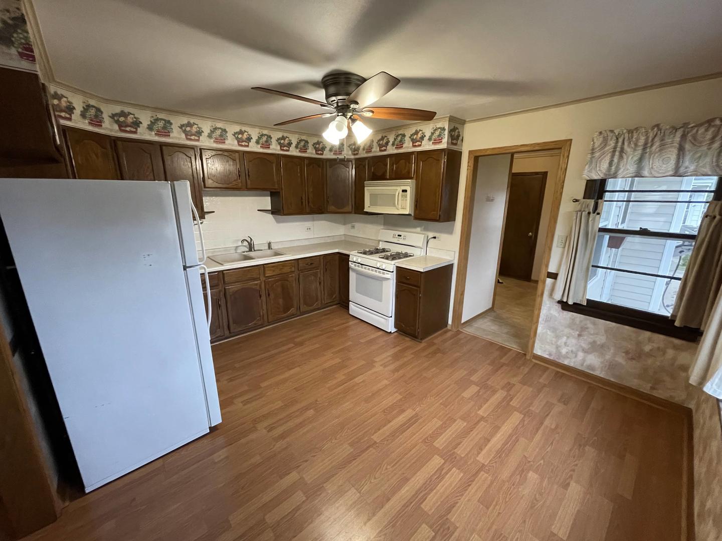10720 Princess Avenue Chicago Ridge, IL 60415 - Photo 14 of 34 a view of a kitchen with a sink and dishwasher a refrigerator with wooden floor