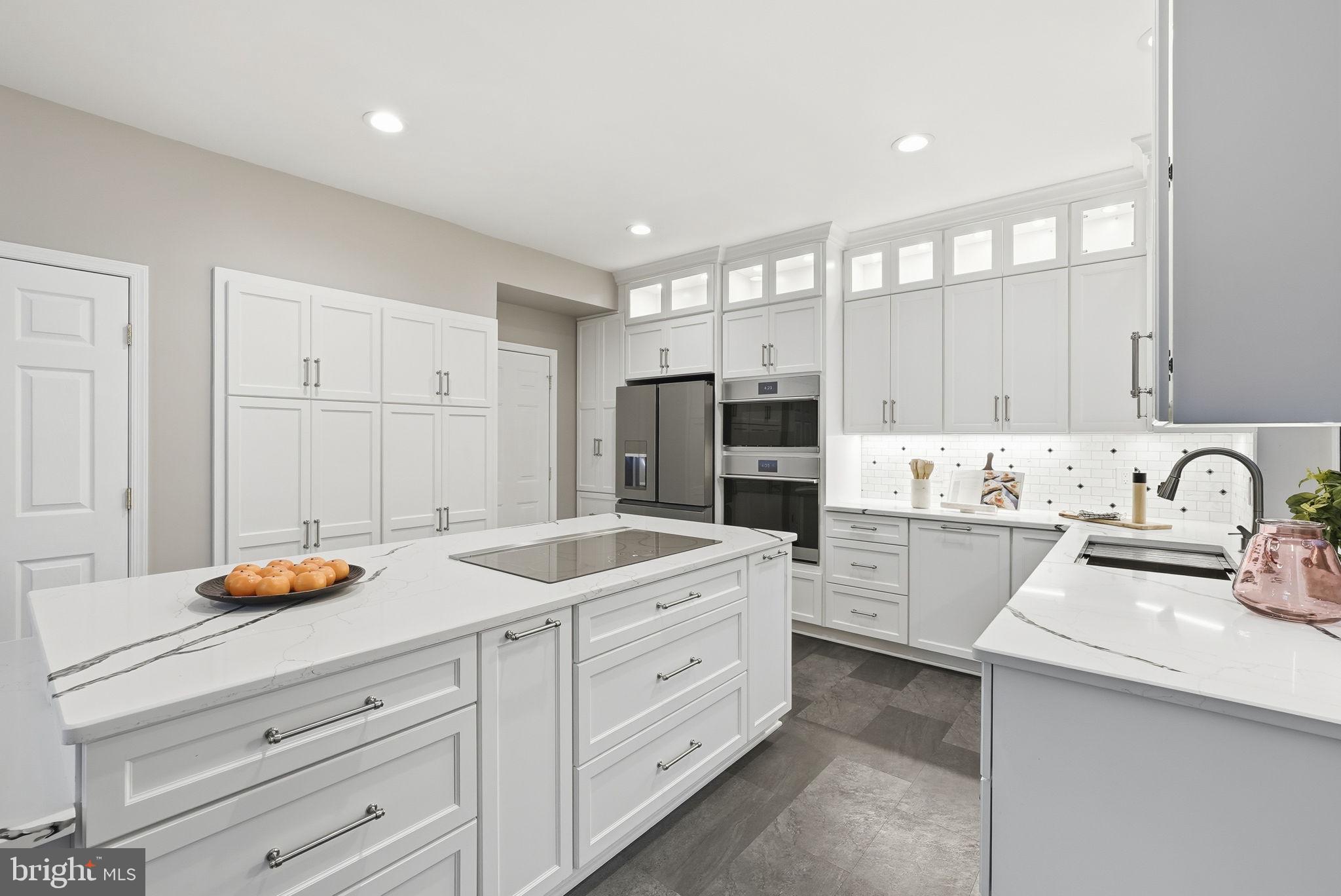 a kitchen with white cabinets and appliances
