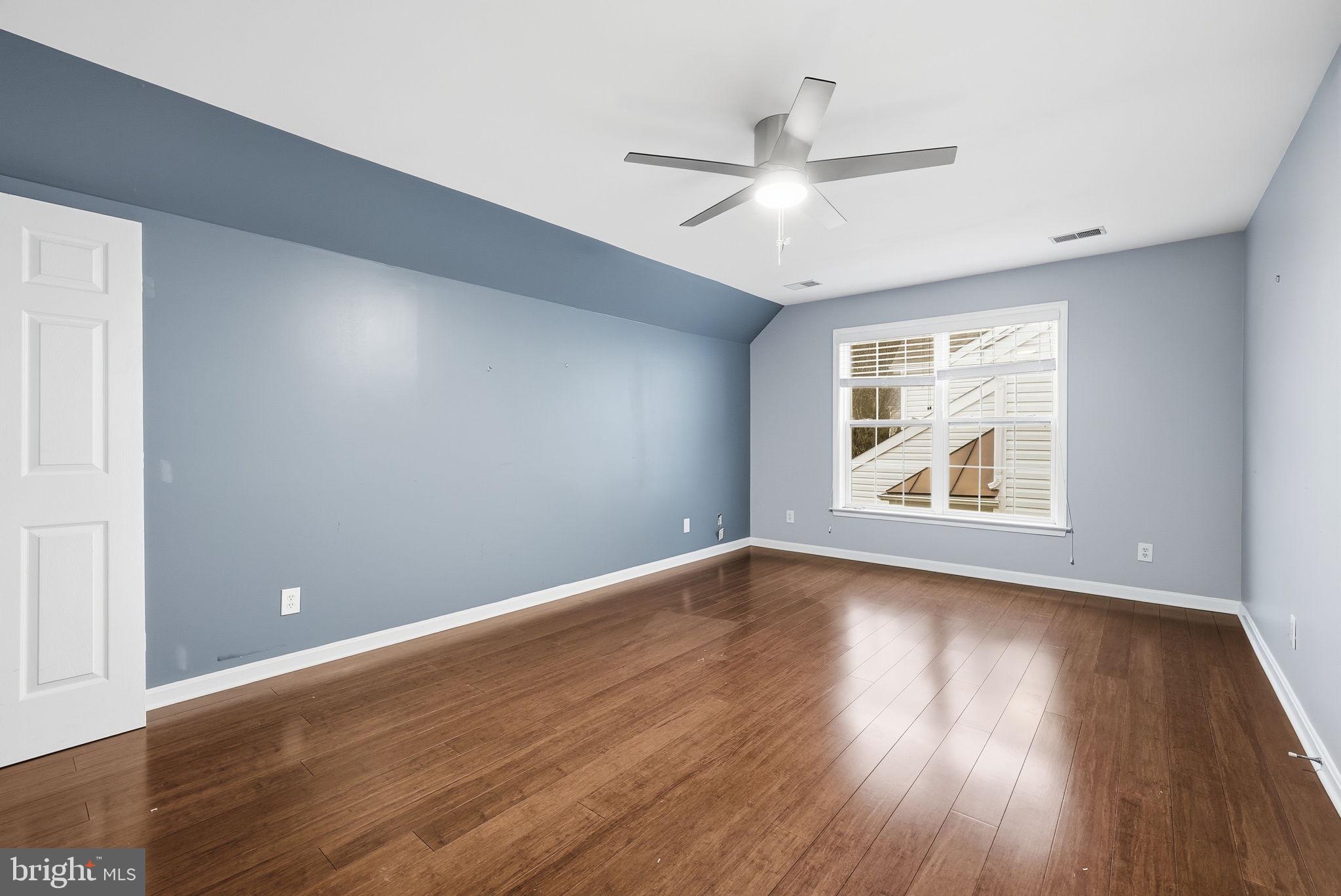 12402 Brown Fox Way Reston, VA 20191 - Photo 32 of 52 an empty room with wooden floor chandelier fan and windows