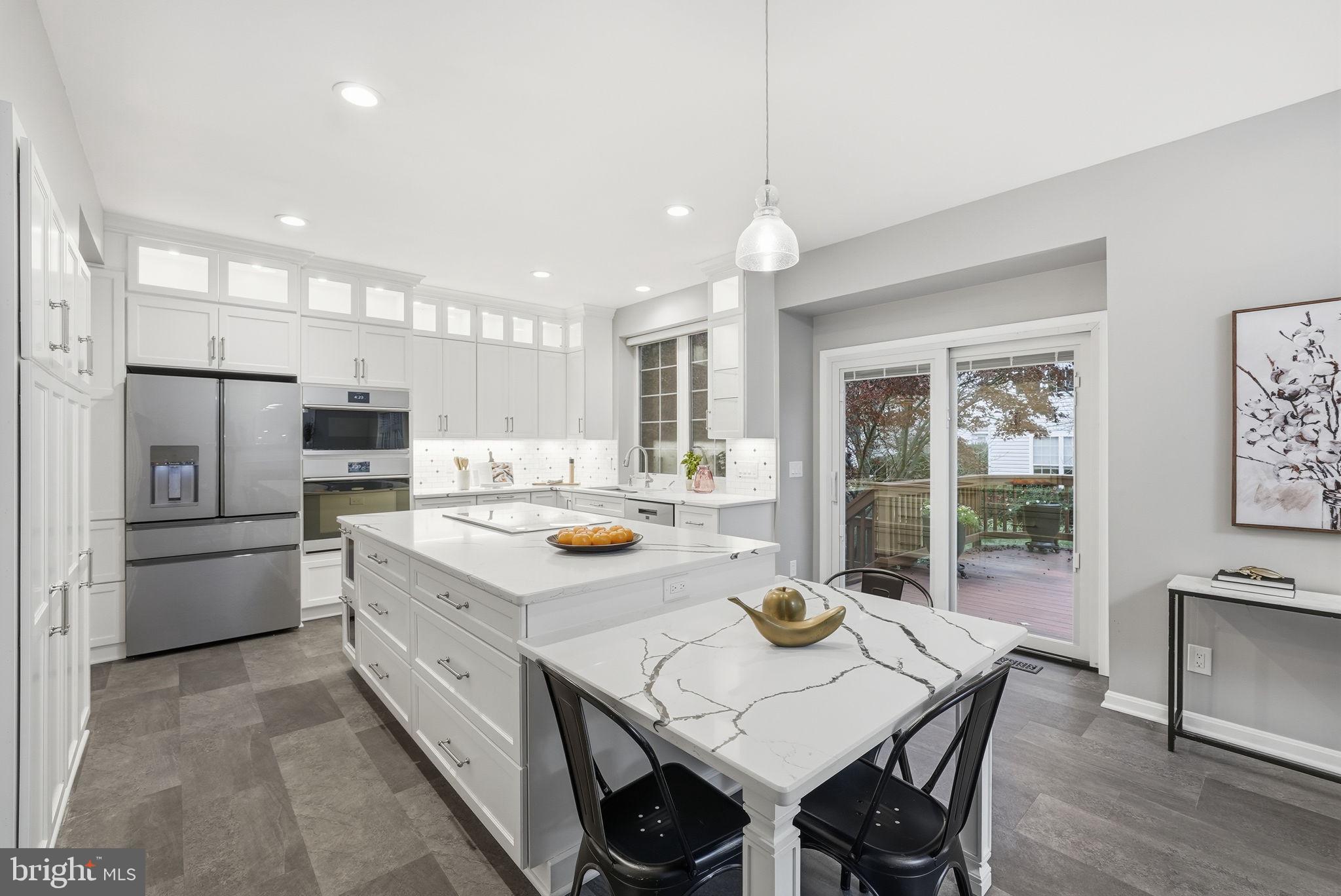 12402 Brown Fox Way Reston, VA 20191 - Photo 5 of 52 a kitchen with a dining table wooden floor and stainless steel appliances
