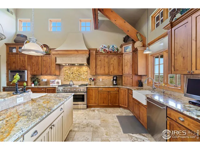 a kitchen with stainless steel appliances granite countertop a stove a sink dishwasher and cabinets with wooden floor