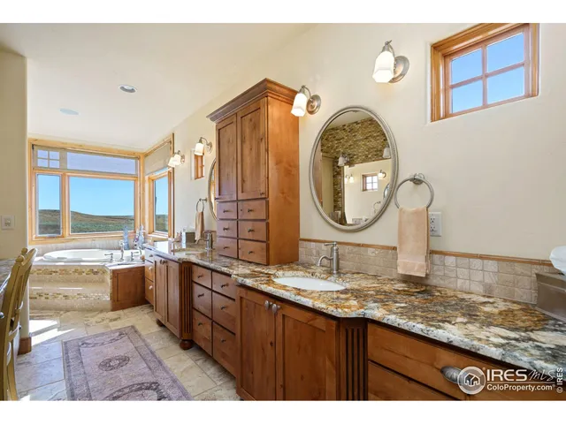 a bathroom with a granite countertop double vanity sink and a mirror